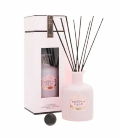 מפיץ ריח 250 מ"ל Rose Blush Portus Cale עם מקלות שחורים מוצג לצד האריזה התואמת בלבן וורוד. - vavaVoom.co.il